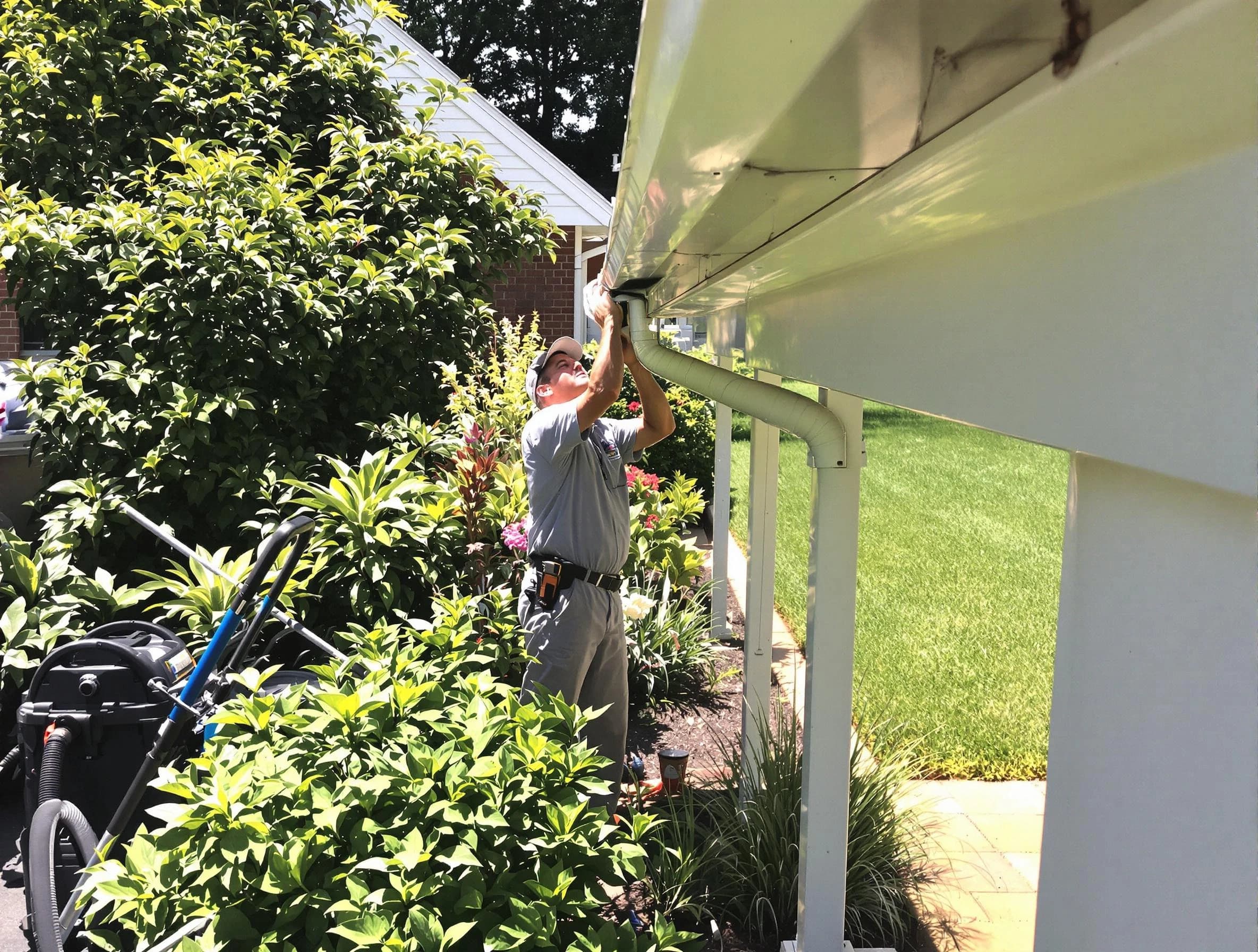 Technician flushing a blockage from a downspout in Avon, OH